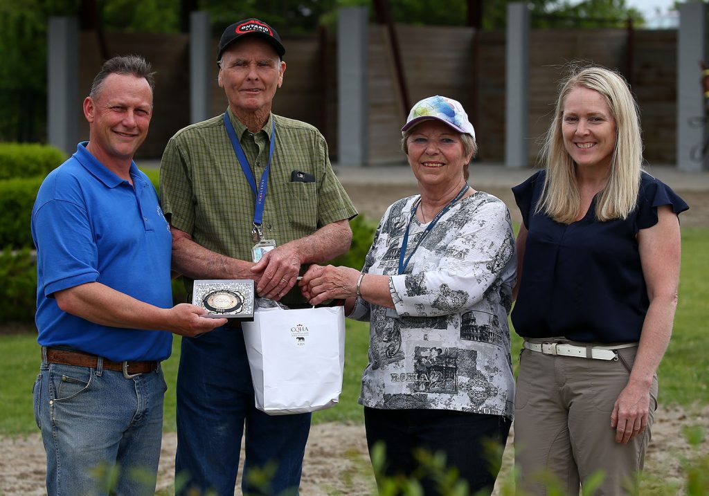 Group presenting plaque and gift outdoors