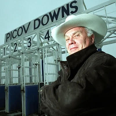 Man with white cowboy hat by starting gates