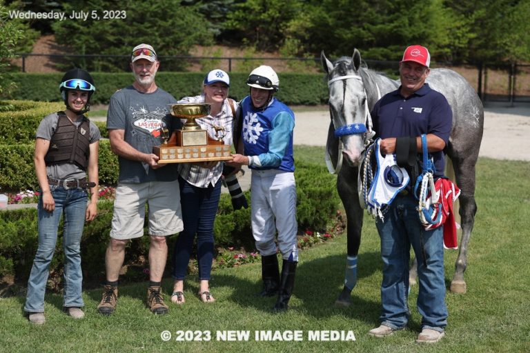 Winning team with gray horse and trophy
