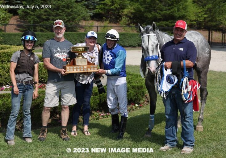 Winning team with gray horse and trophy
