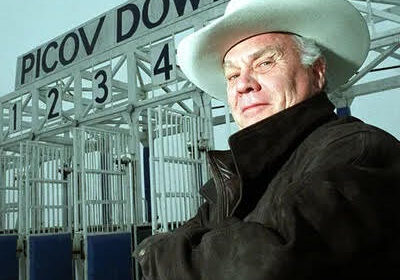 Man with white cowboy hat by starting gates